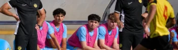 Jugador joven de academia de fútbol en Madrid durante la preparación previa a un partido.