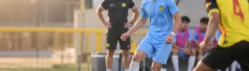 Futbolista joven observa el campo antes de recibir el balón durante un entrenamiento de fútbol