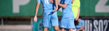 Two Siello players during a game situation, adjusting their positioning as play continues on the field.