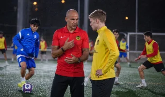 Coach gives feedback to a young football player during a training session in Spain as part of the player’s adaptation process.