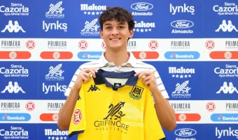 Carter Barron holding a yellow AD Alcorcón shirt during his club presentation.