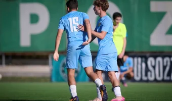 Two Siello players during a game situation, adjusting their positioning as play continues on the field.