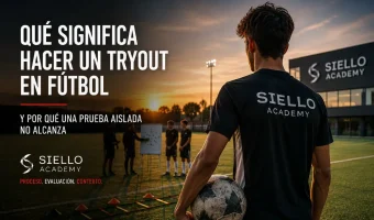 Young football player at Siello Academy in Madrid during a structured tryout evaluation, with coaches analyzing performance, adaptation and tactical context in the background
